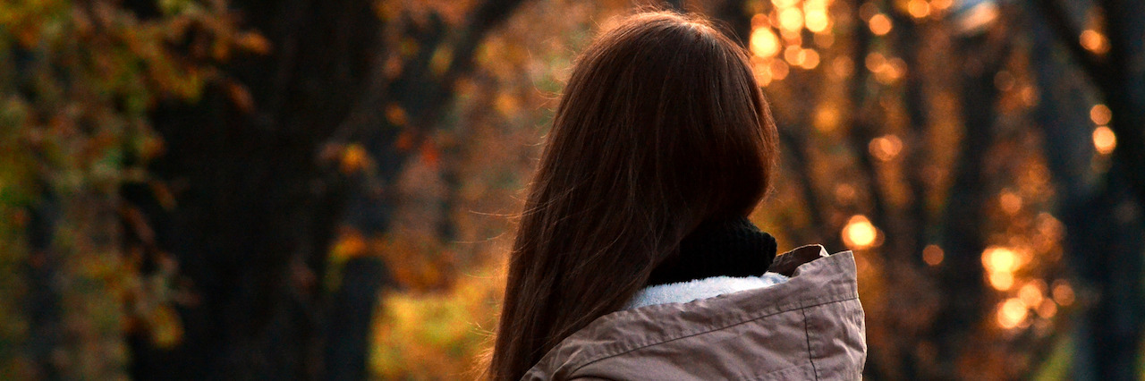 What It's Like to Experience Paranoia Woman alone in autumn park in front of sunset