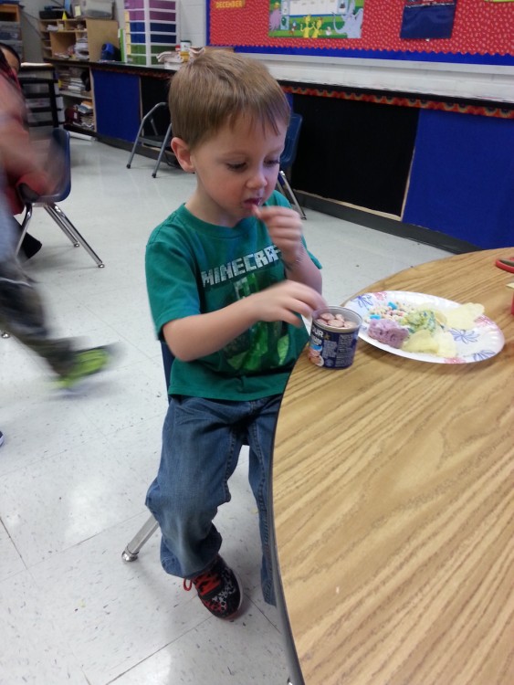 Young boy named Cayden eating a snack at school