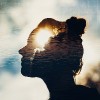 A double exposure of a woman and the sun in her head