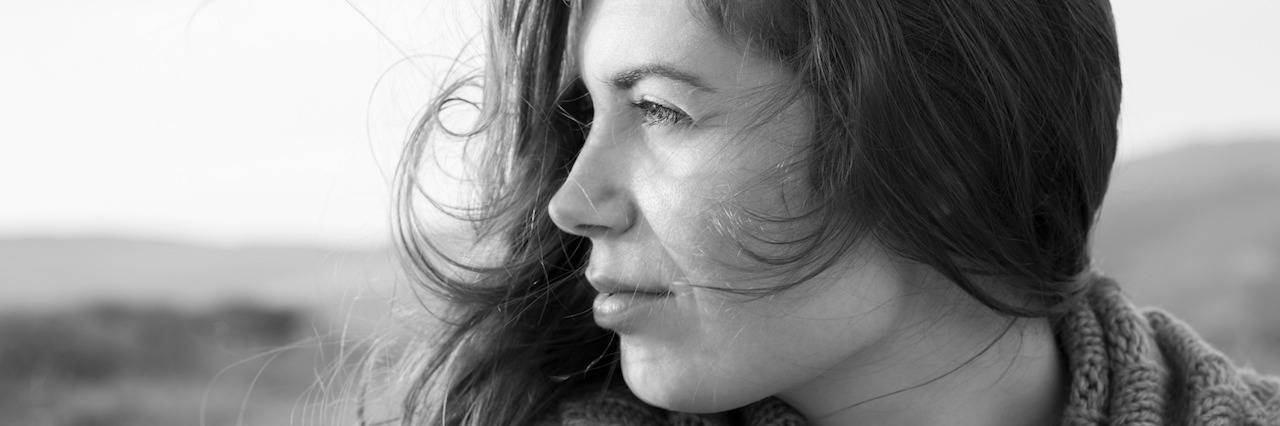 What It Feels Like to Have a Mental Illness Black and white portrait of a wistful young woman looking over her shoulder toward the ocean