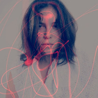 A double exposure image of a woman's face and red lights shining on her