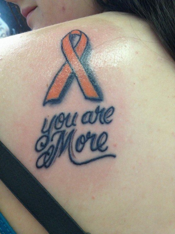 A tattoo of an orange ribbon and text that says, "You are more."