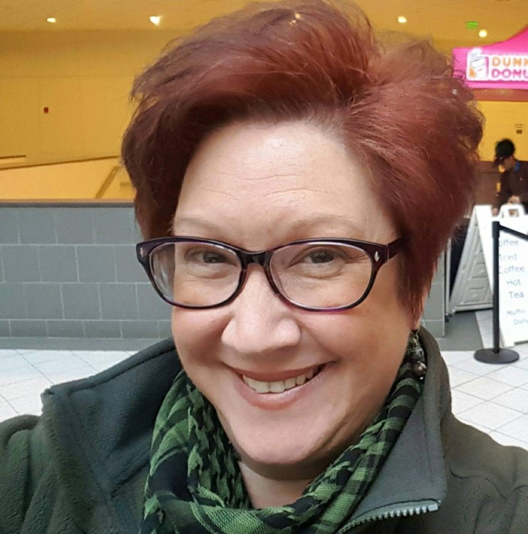 woman with red hair and glasses taking a selfie