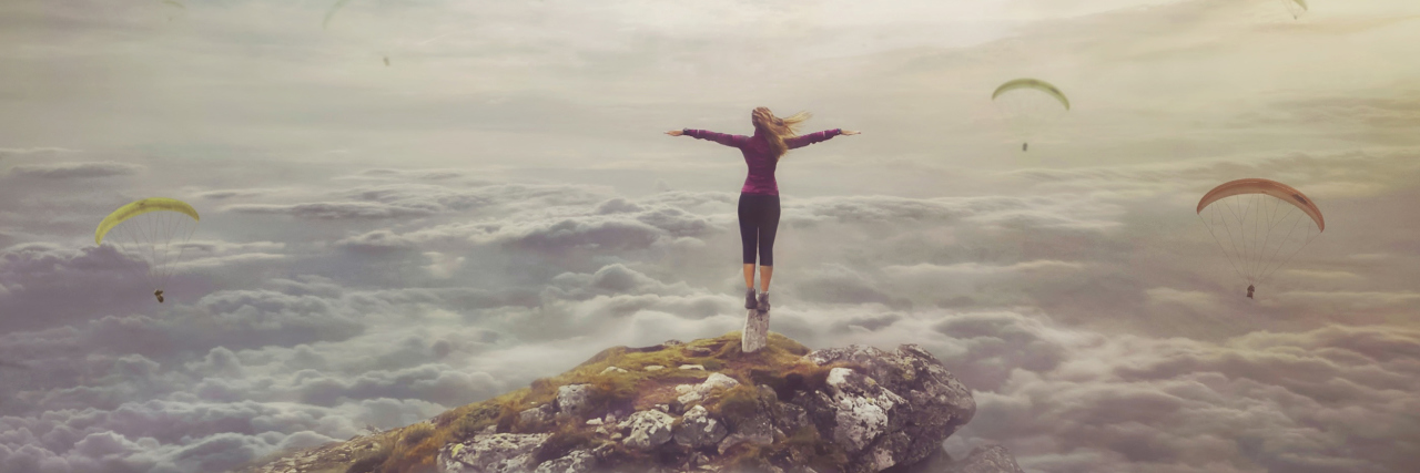 How Maladaptive Daydreaming Makes You a Prisoner in Your Mind surreal picture of woman on rock with upside down city in sky