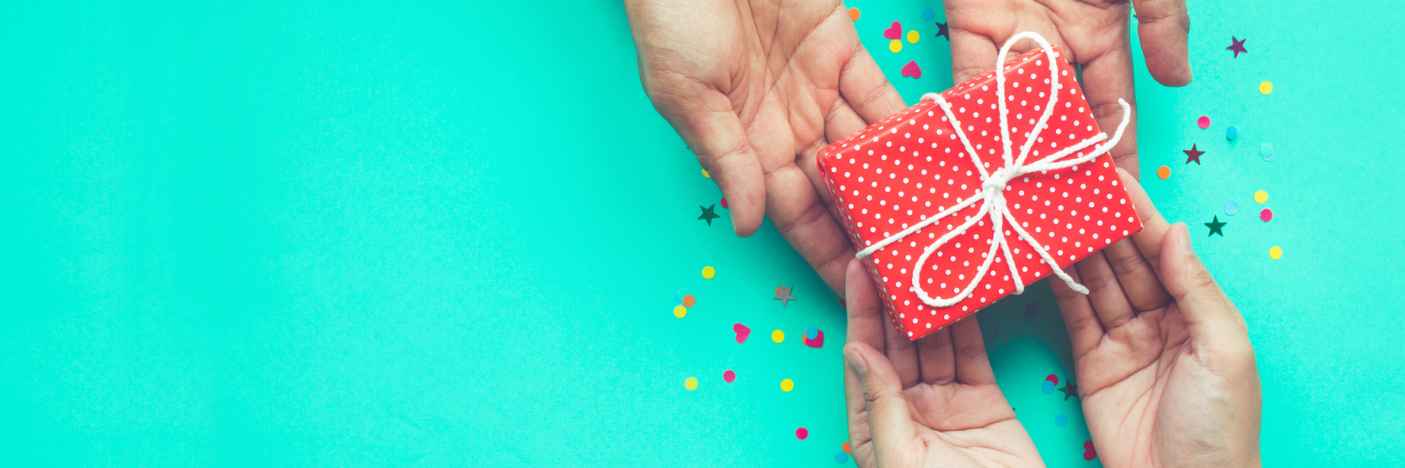 Gifts Your Injured Loved Ones Can Enjoy A man handing a woman a gift, image focusing on hands only.