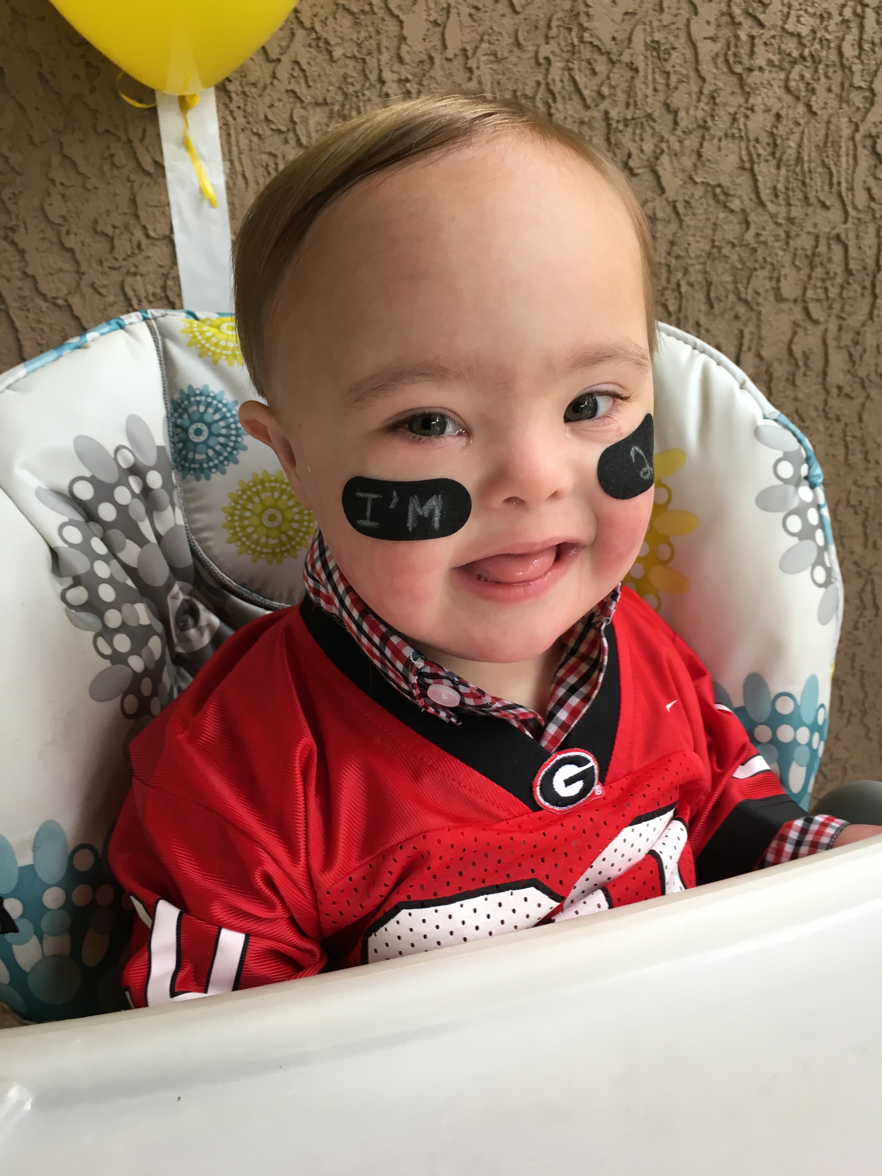 baby with down syndrome in football jersey