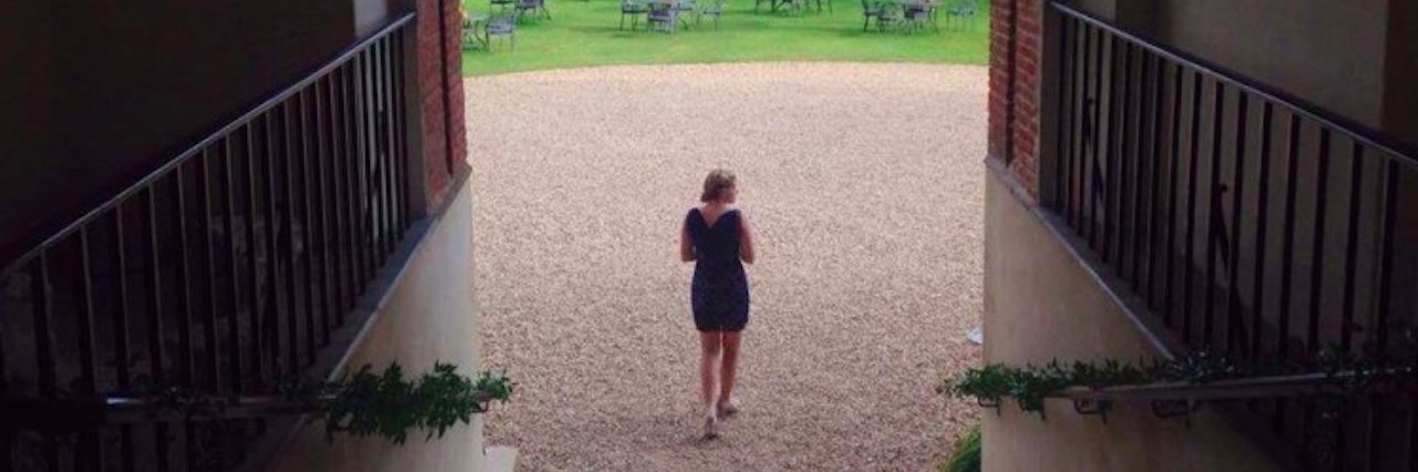 Why the Hardest Part of Dealing With Chronic Illness Is Other People back of woman walking under archway