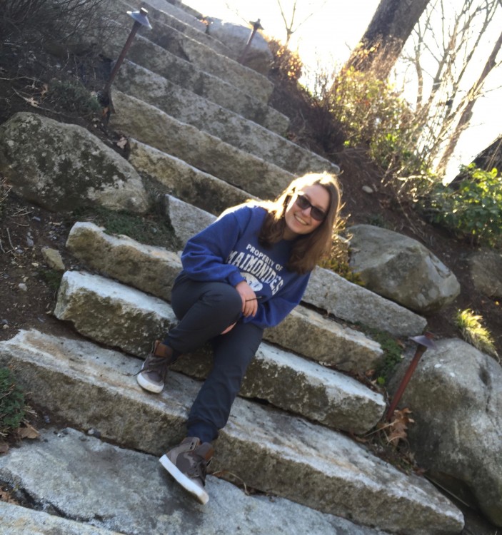 Teen girl sitting on outdoor, stone stairs.