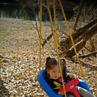 little girl with cantu syndrome in a swing