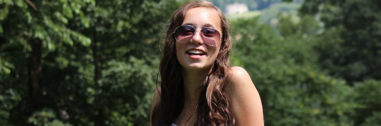 Talking About Chronic Pain on Social Media young woman in white dress standing outside in a field