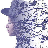 Double exposure of girl wearing hat and autumn tree branches