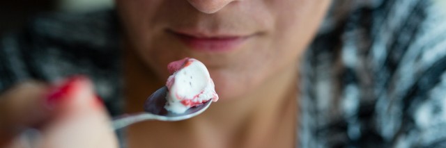 Woman looking at the ice cream on a spoon