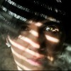 A closeup of a woman's face with smoke to the side and a shadow caste over her face