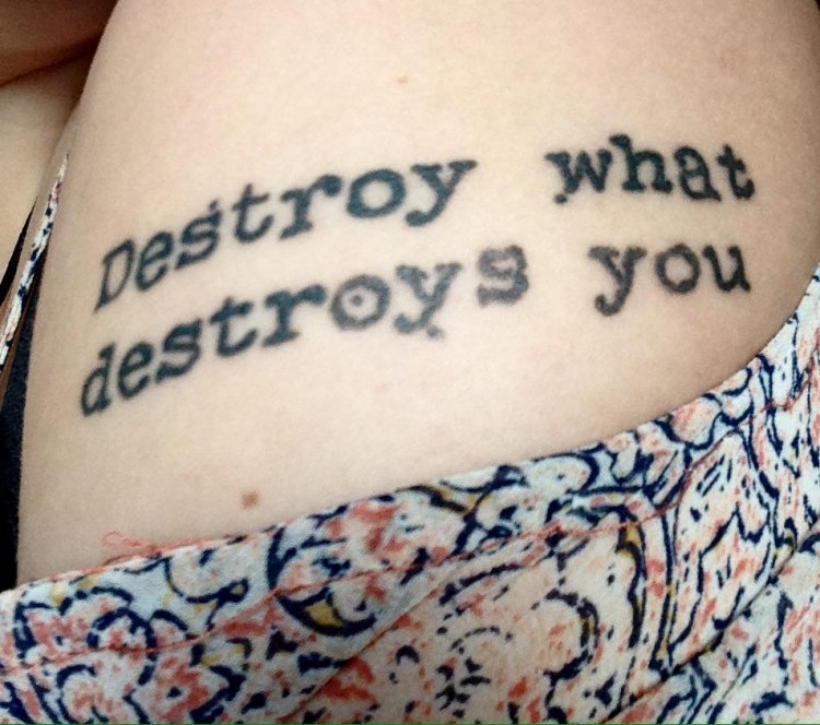 A tattoo that says, "Destroy what destroys you."
