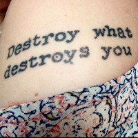 Tattoo that reads "Destroy what destroys you"