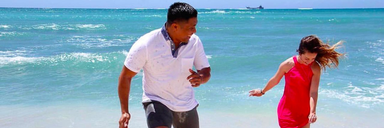 What You Don't See About Living With a Congenital Heart Condition man and woman walking through ocean tide on beach