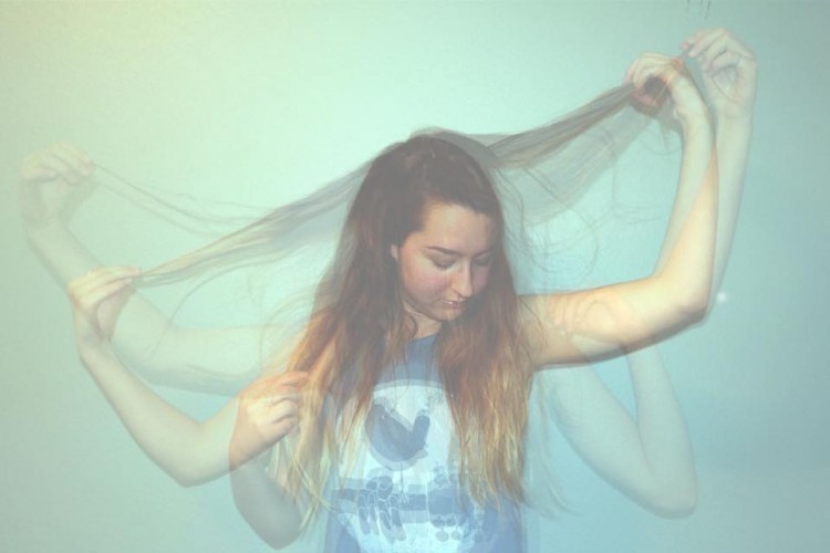 A photograph of a woman tugging on her hair 