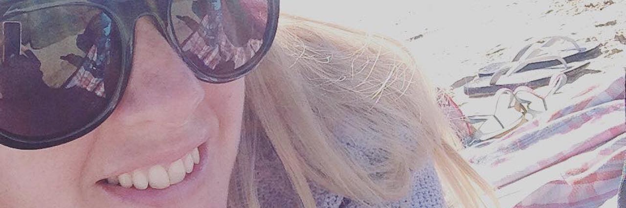 Not Letting Friends See You When You're Sick woman wearing sunglasses and a hat on a beach