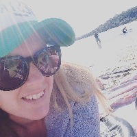woman wearing sunglasses and a hat on a beach