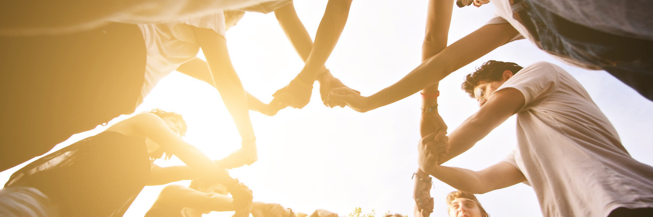 Finding Purpose While Struggling With Depression Group of friends holding hands together showing unity