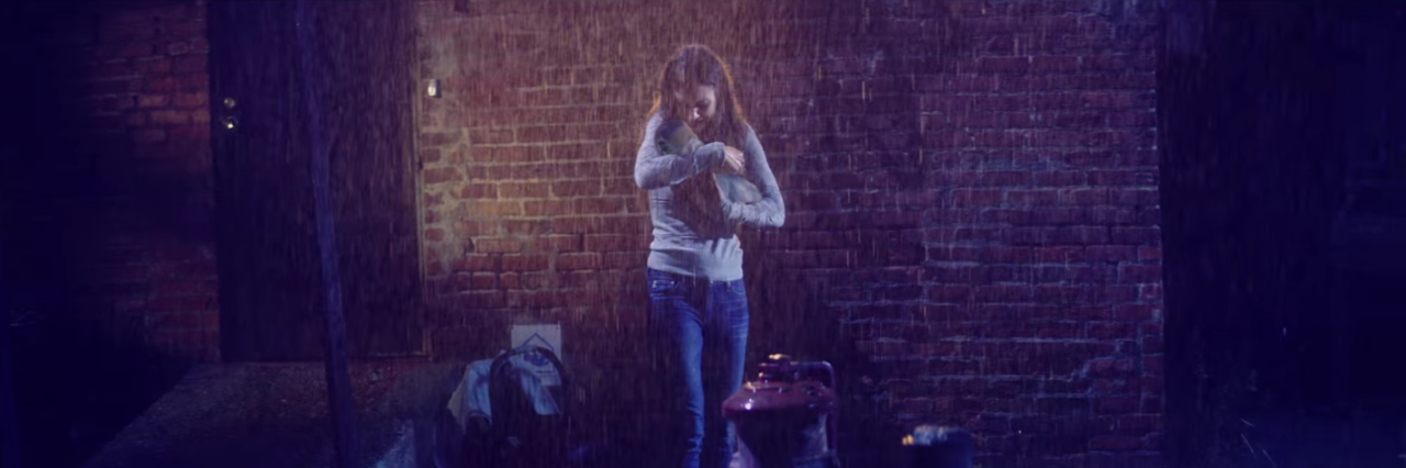 A Playlist for Parents of a Child With Propionic Acidemia woman holding a baby in the rain