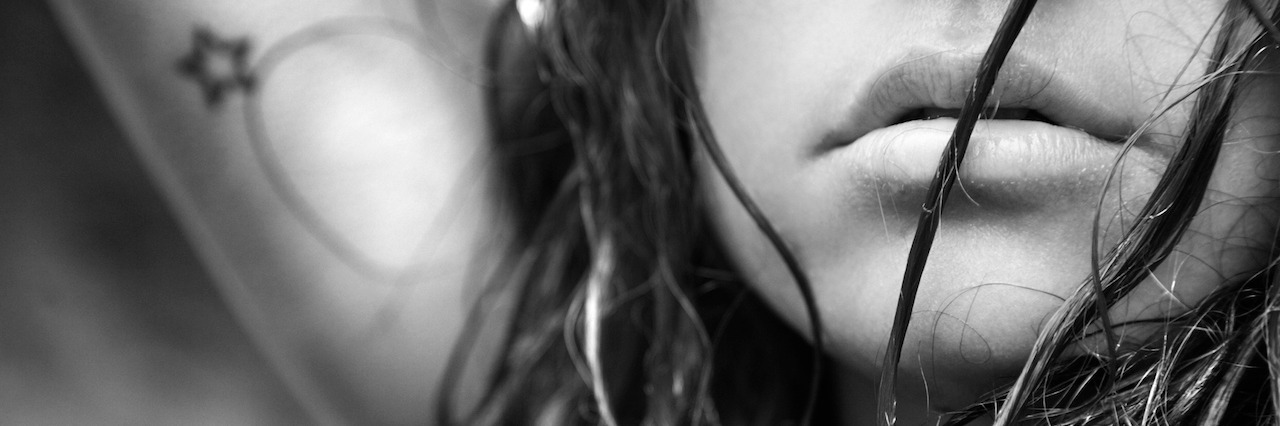 What It's Like to Have Bipolar Disorder and Auditory Hallucinations Young adult Caucasian female face and disheveled hair.