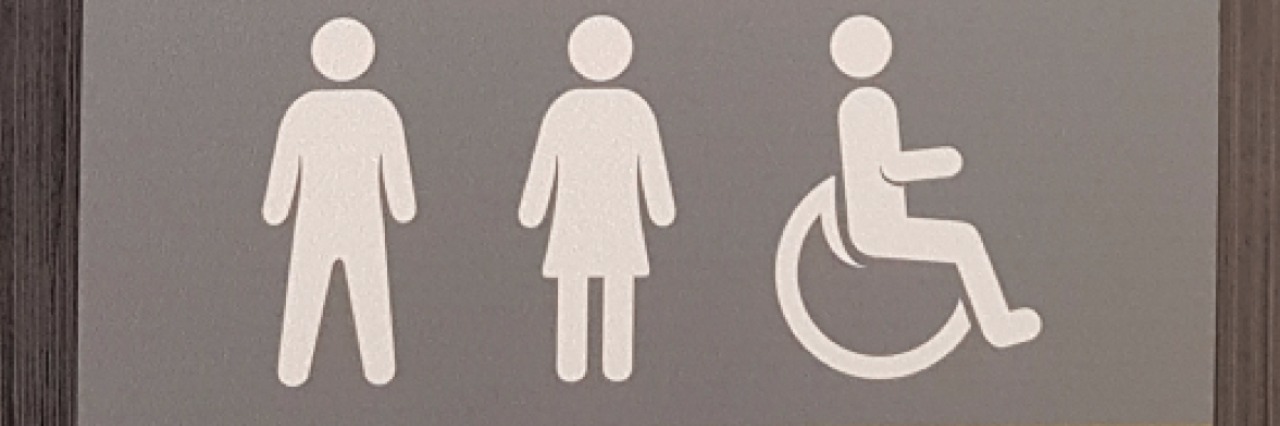 Image of a Tesco bathroom sign which says "not every disability is visible. Accessible toilet." and then shows the symbols for a man, woman and wheelchair sign.