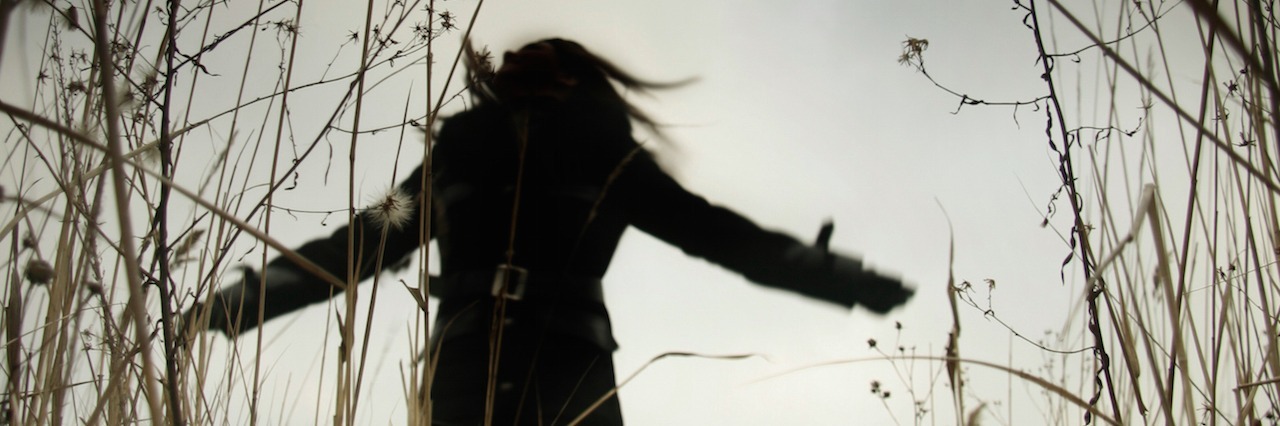 sillouette of a woman running through a field