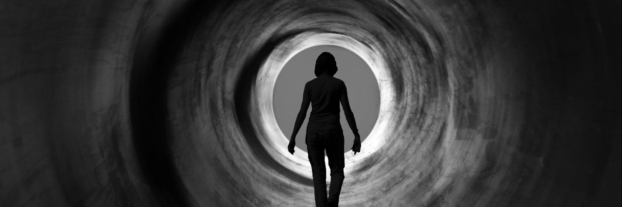 I Found Recovery From My Eating Disorder, but First, All I Felt Was Sadness woman walking down a tunnel towards the light
