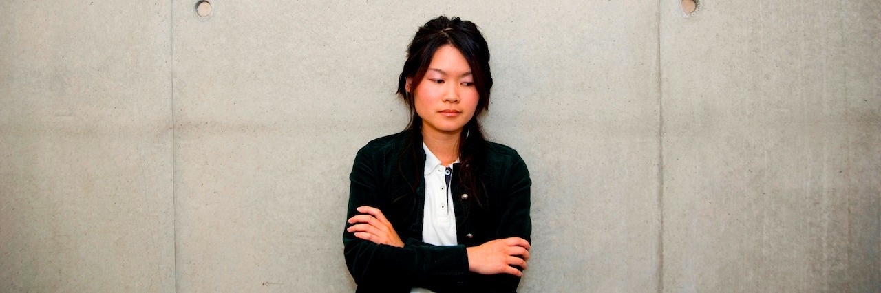 Why Asian-Americans Need to Tell Their Mental Health Stories a woman leaning against a wall