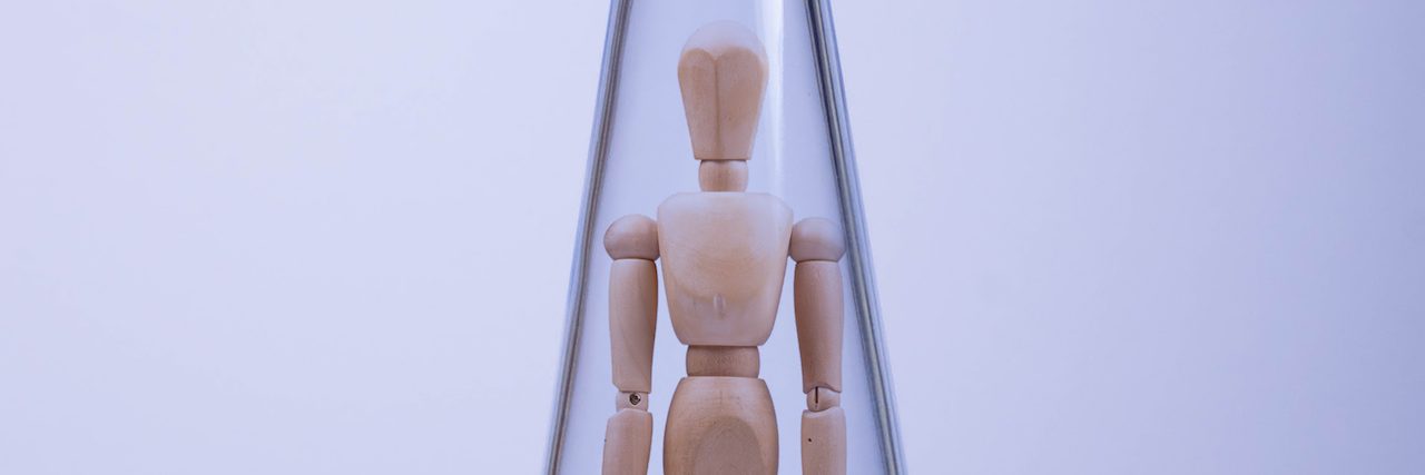 The Problem With Disconnecting From Your Emotions A wooden artists mannequin in a glass bottle