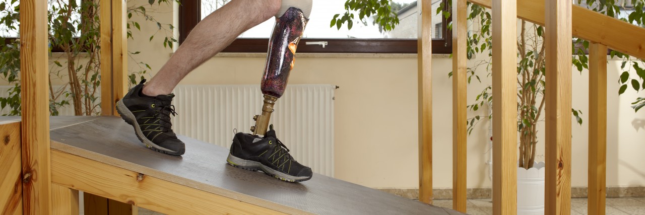 Man walking on ramp with prosthetic leg.
