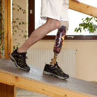 Man walking on ramp with prosthetic leg.