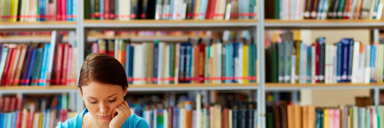 What I've Learned About Failure in Graduate School With Mental Illness Portrait of clever student with open book reading it in college library