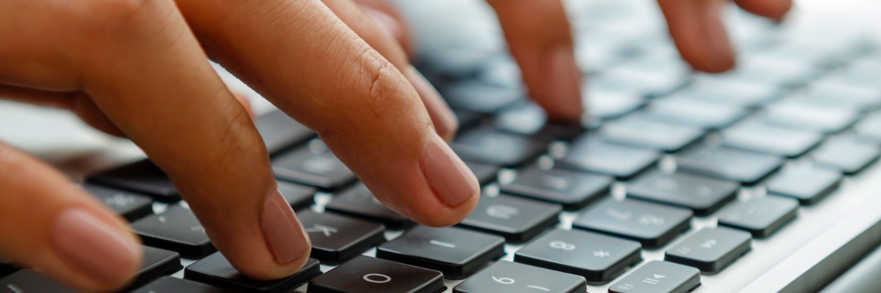 Writing About My Stutter Person typing on laptop