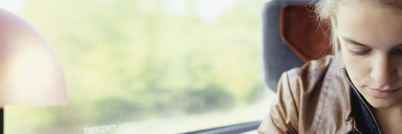 A Letter to My Inner Critic Young woman reading on train