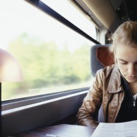 Young woman reading on train