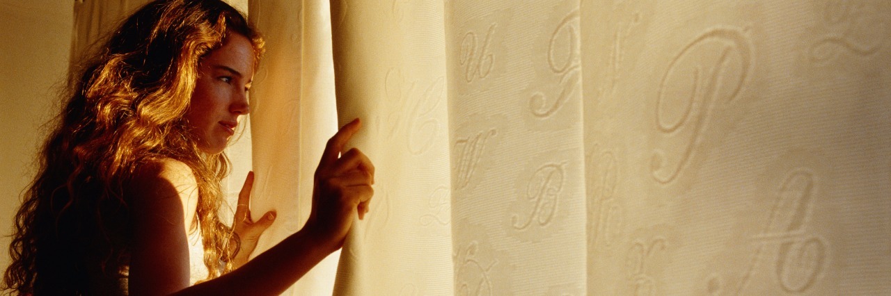 Why Morning Is the Hardest Part of the Day When You're Sick Young woman smiling, looking out window, side view