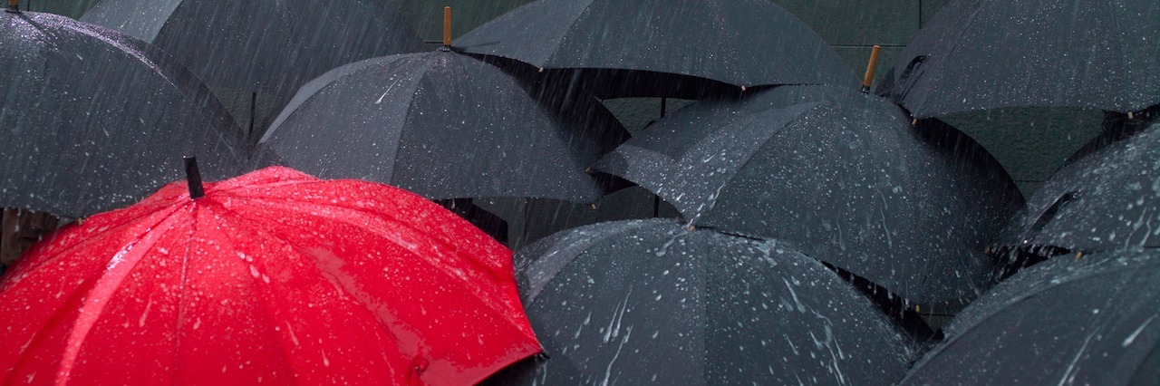 How Mental Illnesses Affects Everyone Differently umbrellas in the rain. One is different from the others.
