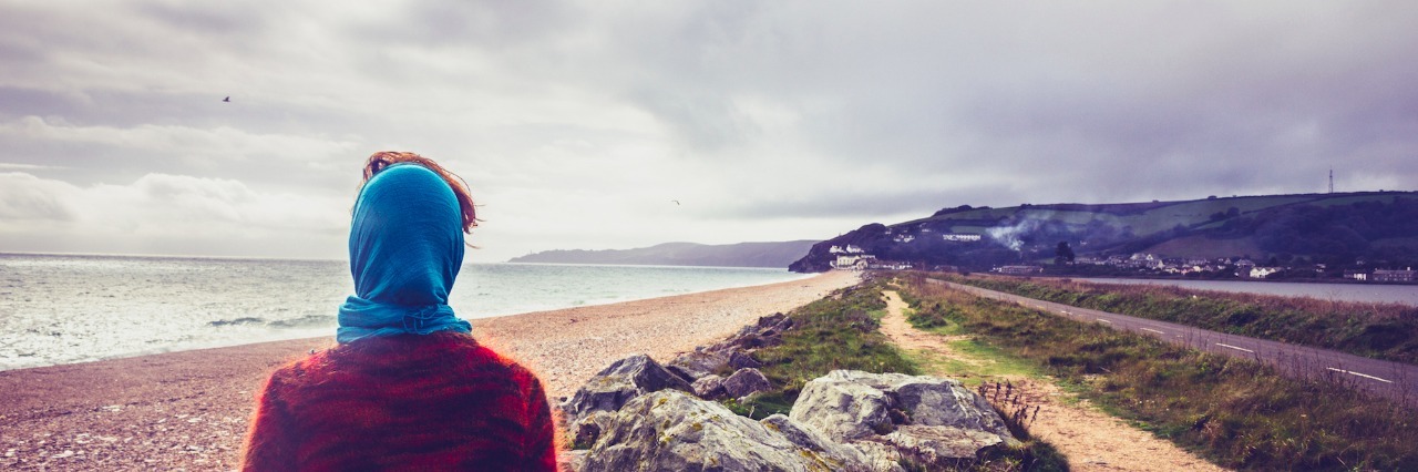 Living With an Undiagnosed Illness: What I've Learned Woman walking on coastal path on beach in autumn
