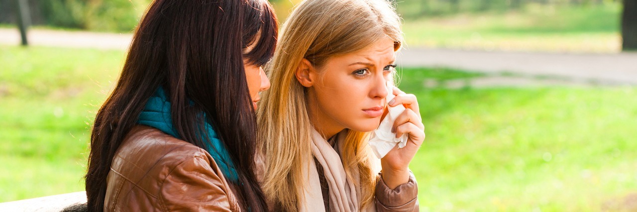 Things People With Mental Illness Wish You Understood Friend comforting a crying friend sitting on a bench outside.