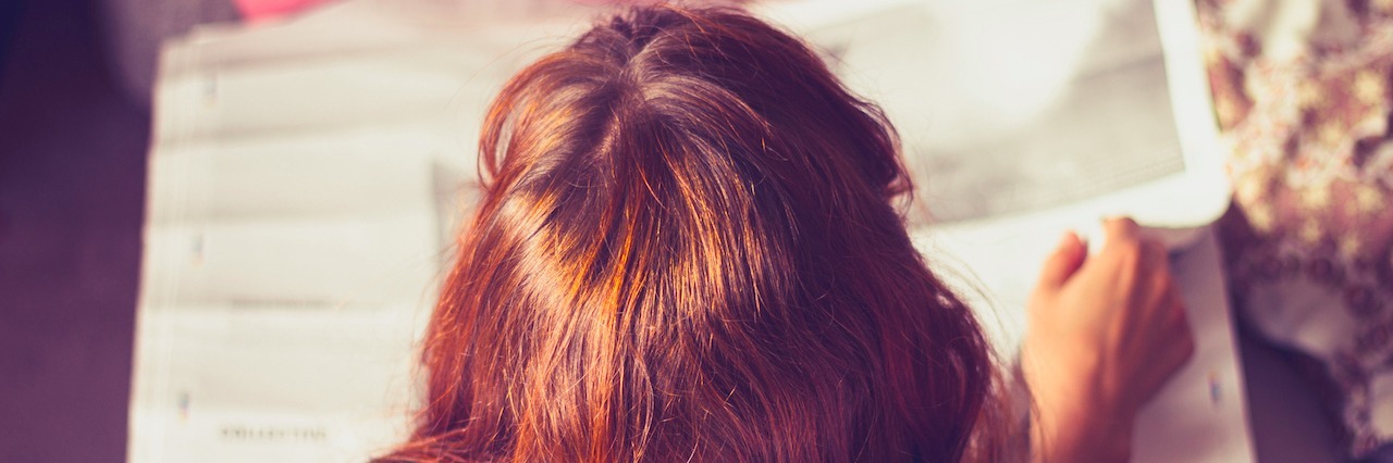 Bipolar Disorder: How I'm Advocating With a Mental Illness Young woman is lying on a bed and is reading a newspaper