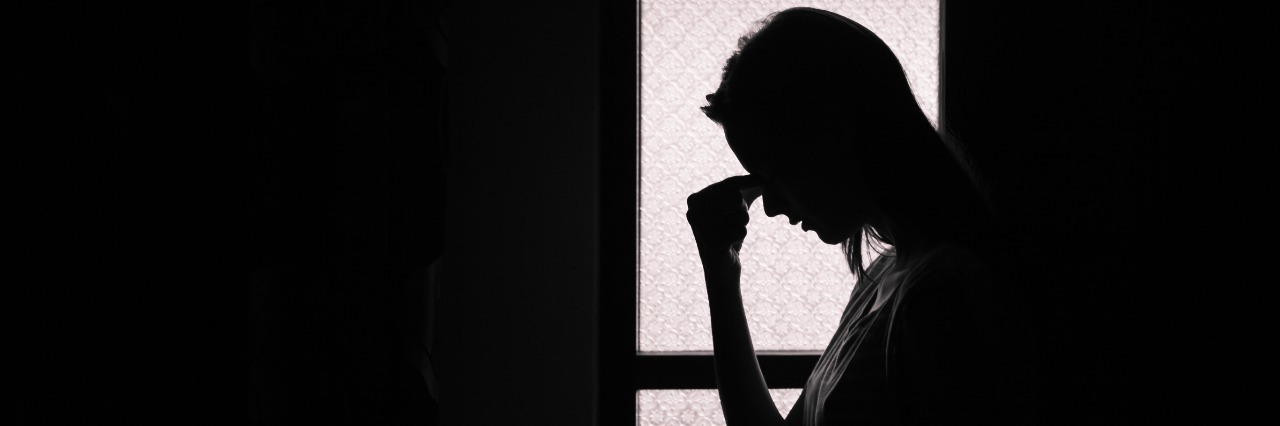 To the Chronic Pain Patient Feeling Guilt silhouette of woman holding head in dark room