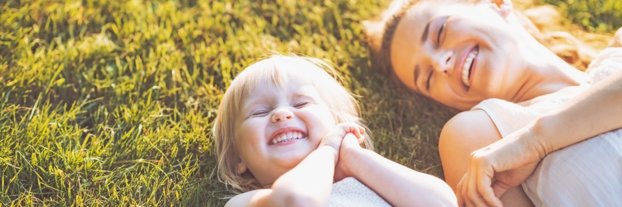 The Exhaustion of Figuring Out Food Protein-Induced Entercolitis smiling mother and baby laying on meadow