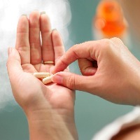 close up of young woman taking pills