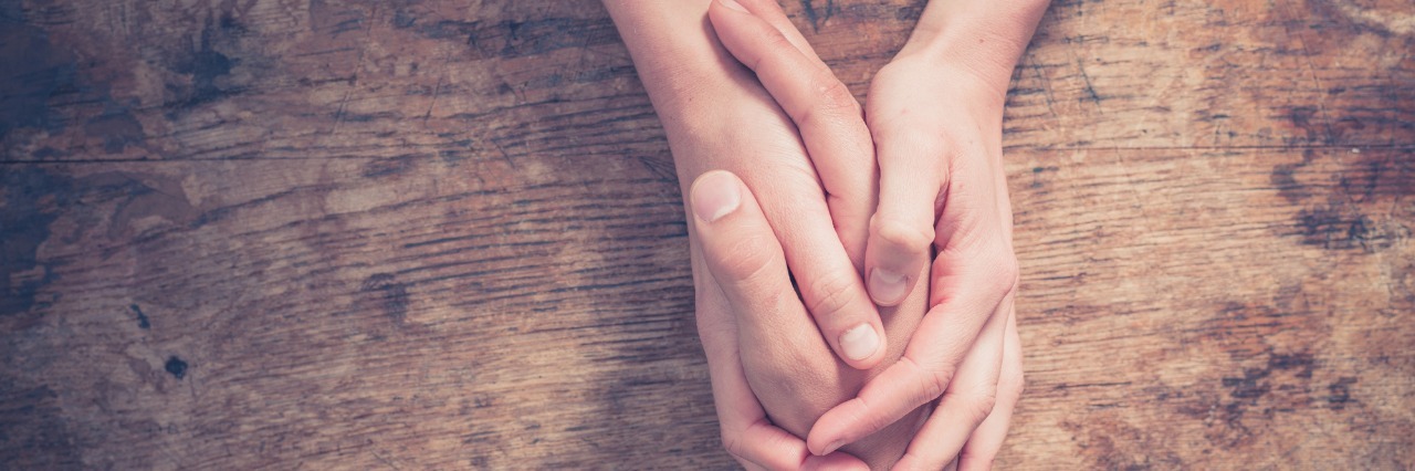 Letter to a Newly Diagnosed Chronic Illness Patient woman holding her friend's hand across a table in comfort