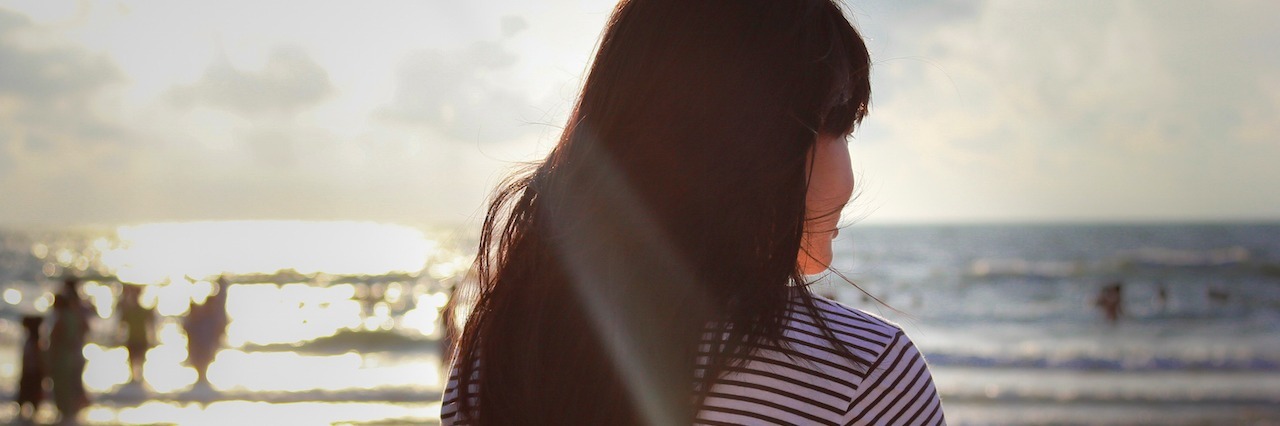 A woman facing the beach