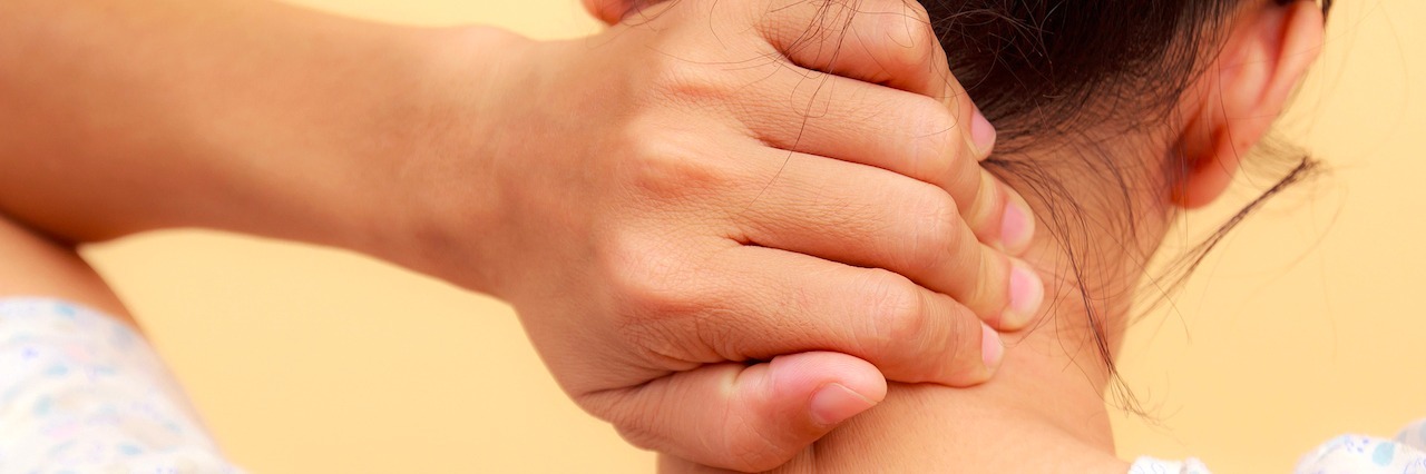 The Physical Effects of Anxiety A woman grabbing the back of her neck