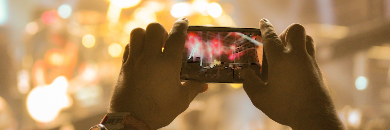 Concerts to Cope With Depression: Why I Take Videos and Pictures Taking picture at a music concert