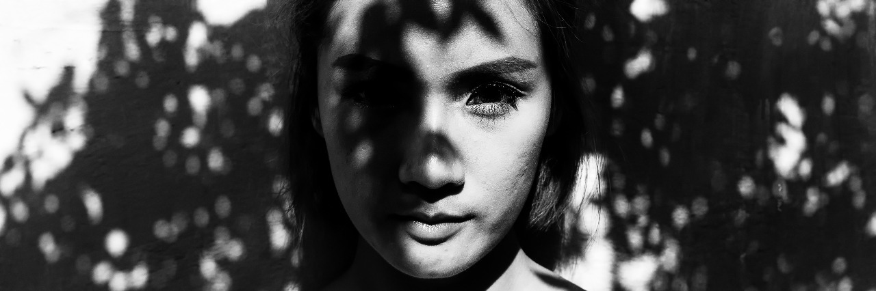 A Sample Scholarship Essay From Someone With Asperger's Syndrome Young woman standing under tree shadows